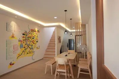 a dining room with a table and a map on the wall at Risa Hostel - Female Only for Solo Travelers in Bangkok