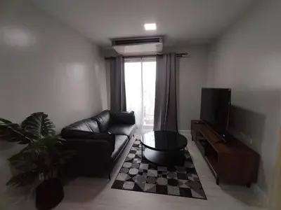 a living room with a couch and a tv at MeStlye BangNa - Baan Win in Bangna