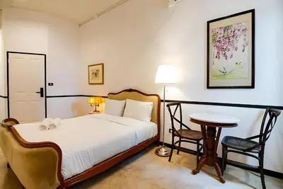 a bedroom with a bed and a table and chairs at xx The Character Yaowarat เดอะ คาแรคเตอร์ เยาวราช ตรอกข้าวสาร in Samphanthawong