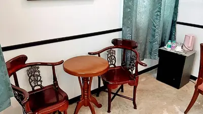 a room with two chairs and a wooden table and two chairs at xx The Character Yaowarat เดอะ คาแรคเตอร์ เยาวราช ตรอกข้าวสาร in Samphanthawong