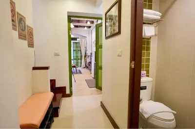 a bathroom with a toilet and a hallway at Nivas Wanit 2BR 1SFB Yaowarat MRT EntireHome 80SQM in Bangkok