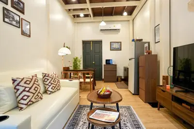 a living room with a white couch and a table at Nivas Wanit 3BR 1SFB Yaowarat MRT EntireHome 85SQM in Bangkok