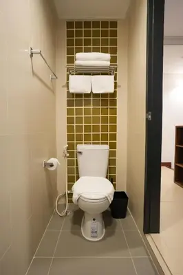 a bathroom with a white toilet and towels at Nivas Wanit 3BR 1SFB Yaowarat MRT EntireHome 85SQM in Bangkok