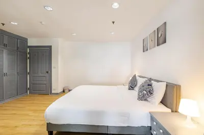 a bedroom with a large white bed in a room at Cozy 2BR Apt in Central Bangkok 5 mins BTS 110 SQM by MattCo in Bangkok
