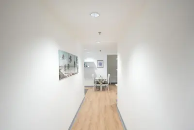 a hallway with white walls and a dining room at Cozy 2BR Apt in Central Bangkok 5 mins BTS 110 SQM by MattCo in Bangkok