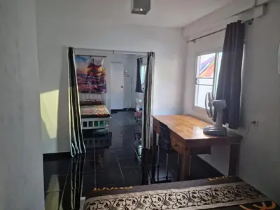 a room with a desk and a tv and a mirror at Jatujak Bangkok guesthouse in Sathani Bang Su