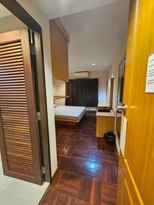 a small room with a bed and a wooden floor at Mrchow Nana in Bang Kapi