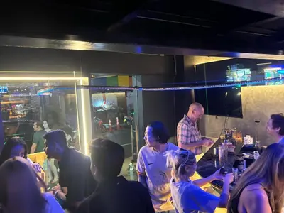 a group of people standing around a bar at Mrchow Nana in Bang Kapi
