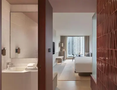 a bathroom with a sink and a bed in a room at Kromo Bangkok, Curio Collection By Hilton in Bangkok