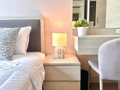 a bedroom with a bed with a lamp on a table at Luxury & Bright 1 Bedroom - Asoke in Bangkok