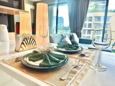 a table with two plates and two wine glasses at Luxury & Bright 1 Bedroom - Asoke in Bangkok