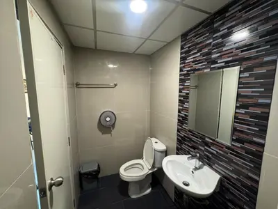 a bathroom with a toilet and a sink and a mirror at Natthapimon in Bangkok Yai
