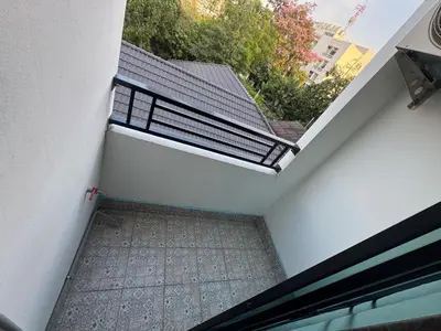 a balcony with a bench on the side of a building at Natthapimon in Bangkok Yai
