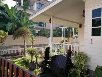 a porch of a house with a chair and a fence at Baan Chay Klong, Canal side Classic Home 2BRs in Ban Bang Toei (1)