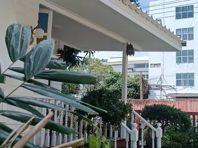a white fence in front of a house with a white picket at Baan Chay Klong, Canal side Classic Home 2BRs in Ban Bang Toei (1)