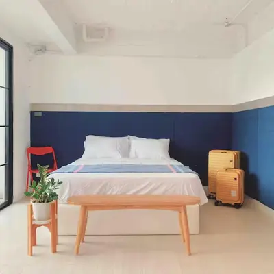 a bedroom with a bed with a blue wall at The Local Heritage Loft Mansion in Bangkok