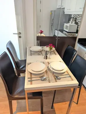 a dining room table with black chairs and a kitchen at Executive 2 Bed Nana BTS 100m Bangkok Skyline in Bangkok