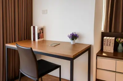 a desk in a room with a chair and a phone at Cozy, Spacious 2-Bedder with City, Park View, Near Nana BTS in Bangkok