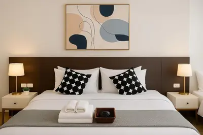 a bedroom with a large bed with black and white pillows at Cozy, Spacious 2-Bedder with City, Park View, Near Nana BTS in Bangkok