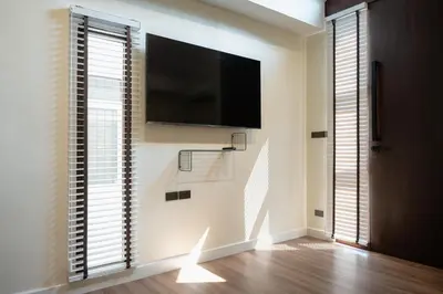 a living room with a flat screen tv on a wall at Morya House in Bangkok