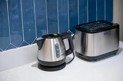 a tea kettle and a toaster sitting on a counter at Morya House in Bangkok