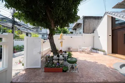 a courtyard with a tree and a white building at Morya House in Bangkok