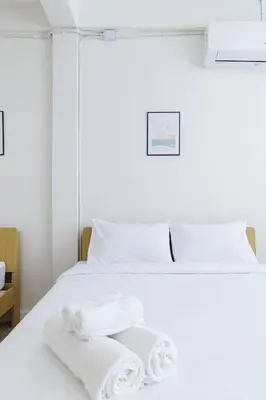 a white bed with towels on top of it at A Townhouse 100m from BTS Bangchak in Phra Khanong