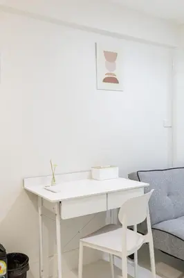 a white desk with a chair and a couch at A Townhouse 100m from BTS Bangchak in Phra Khanong