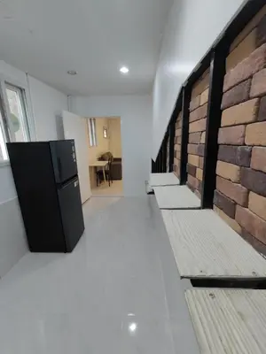 a room with a brick wall and a hallway with benches at Am Am Place แอม แอม เพลส in Bangkok