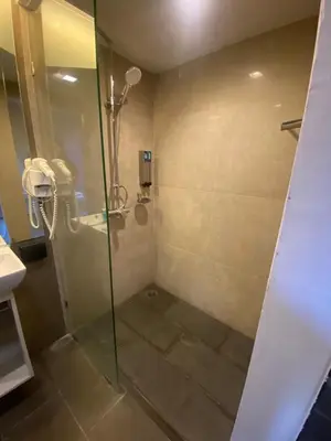 a shower with a glass door in a bathroom at The Xtreme Suites in Bangkok
