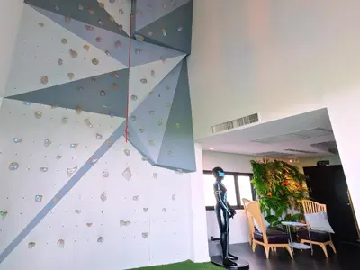 a man standing in front of a climbing wall at The Xtreme Suites in Bangkok