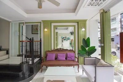 a living room with a couch and purple pillows at Skutan-MTB Sutthisan in Bangkok