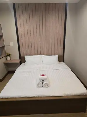 a bed with two towels and two candles on it at Victory place 3 in Bangkok