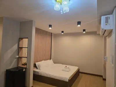 a small room with a bed and a chandelier at Victory place 3 in Bangkok