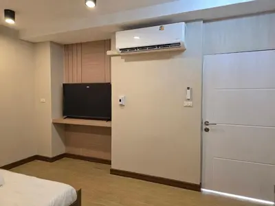 a room with a door and a tv and a bed at Victory place 3 in Bangkok