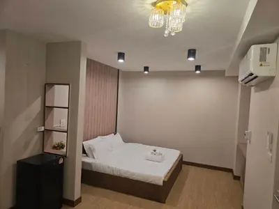 a small room with a bed and a chandelier at Victory place 3 in Bangkok