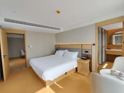 a bedroom with a large white bed and a chair at \u66fc\u8c37\u4e1c\u65b9\u9152\u5e97 in Bangkok