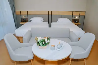 a room with two beds and a white table and chairs at \u66fc\u8c37\u4e1c\u65b9\u9152\u5e97 in Bangkok