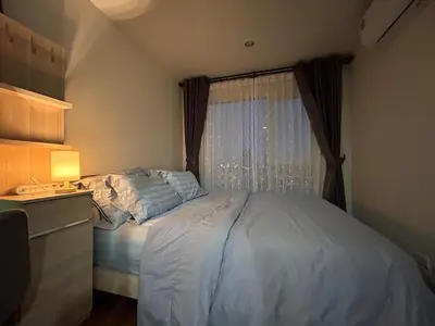 a small bedroom with a bed and a window at Charming condo 5min walk to MRT near DMK,Chatuchak in Bangkok