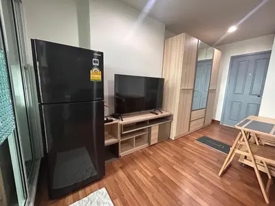 a kitchen with a black refrigerator and a television at Charming condo 5min walk to MRT near DMK,Chatuchak in Bangkok