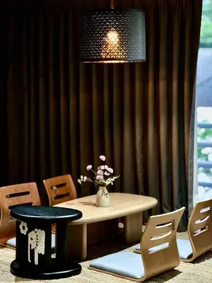 a table and chairs with a vase of flowers at 5BR Villa with Private Pool Sukhumvit 10mins BTS in Bangkok