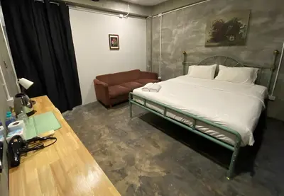 a bedroom with a bed and a couch in it at XX GO INN BTS Ari - BTS Ari Station in Sathani Sam Sen