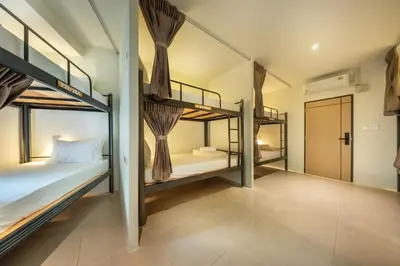 a room with three bunk beds and a hallway at SHIN Hotel Victory Monument in Bangkok
