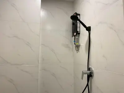 a shower in a bathroom with a phone on the wall at Luna Residence in Ban Bang Phai