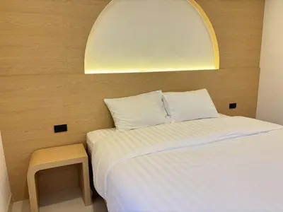 a small bedroom with a bed and a stool at Luna Residence in Ban Bang Phai