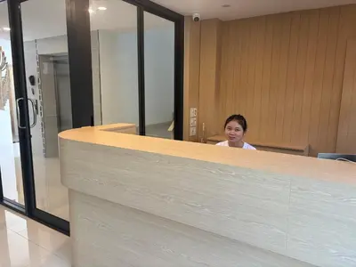a woman sitting at a counter in an office at Luna Residence in Ban Bang Phai