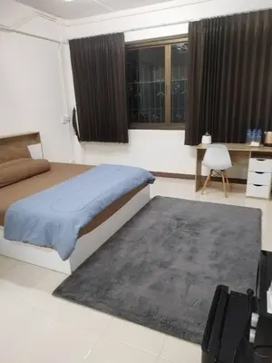 a bedroom with a bed and a rug and windows at Homey Place 2 in Ban Song Hong