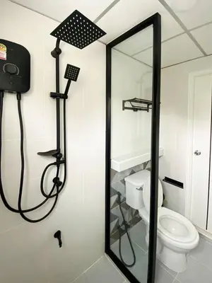a bathroom with a shower with a toilet and a mirror at Homey Place 2 in Ban Song Hong