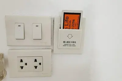 an electrical outlet with a cell phone plugged into it at Zenith Life Hotel in Ban Bang Khen (1)