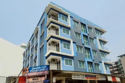 a blue building with white balconies on a city street at Zenith Life Hotel in Ban Bang Khen (1)